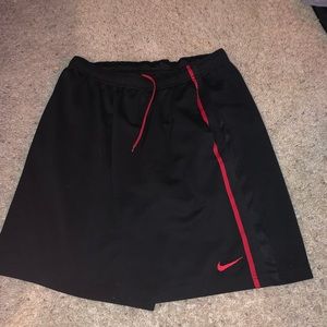 Black Nike shorts with red stripe